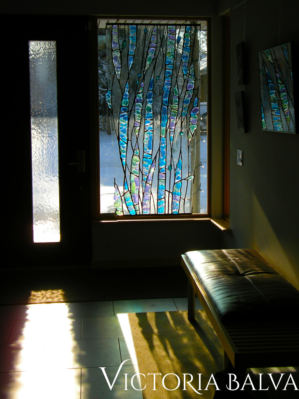 Contemporary stained, fused and leaded glass sculpture for the foyer window of a private residence after installation