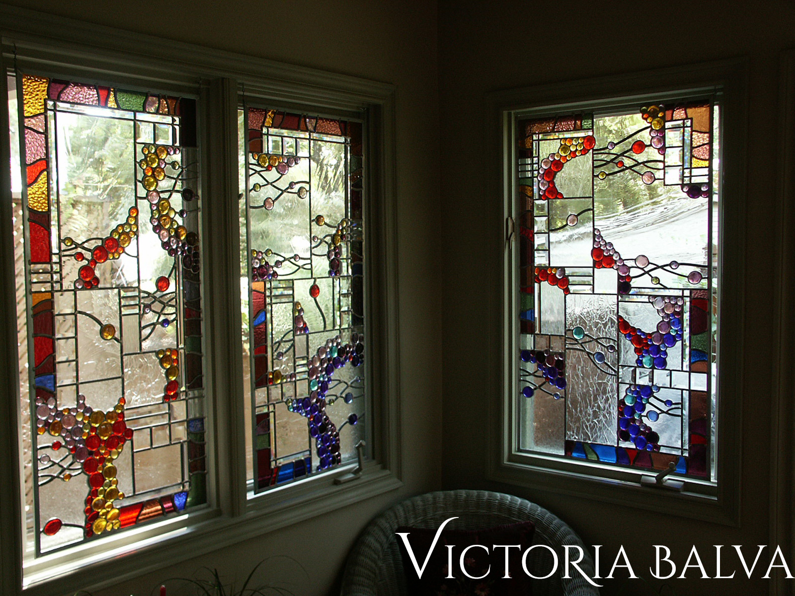 Stained leaded glass suspended panels with nuggets and bevelled glass for solarium room windows after installation